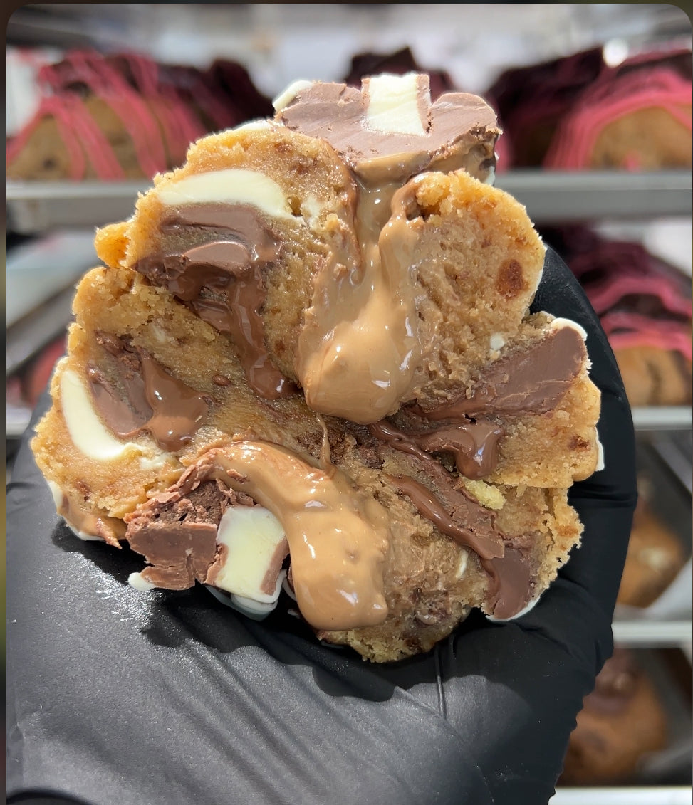 Close-up of our Kinder Bueno Loaded Cookie, with hazelnut filling oozing out, showcasing the irresistible gooey center.