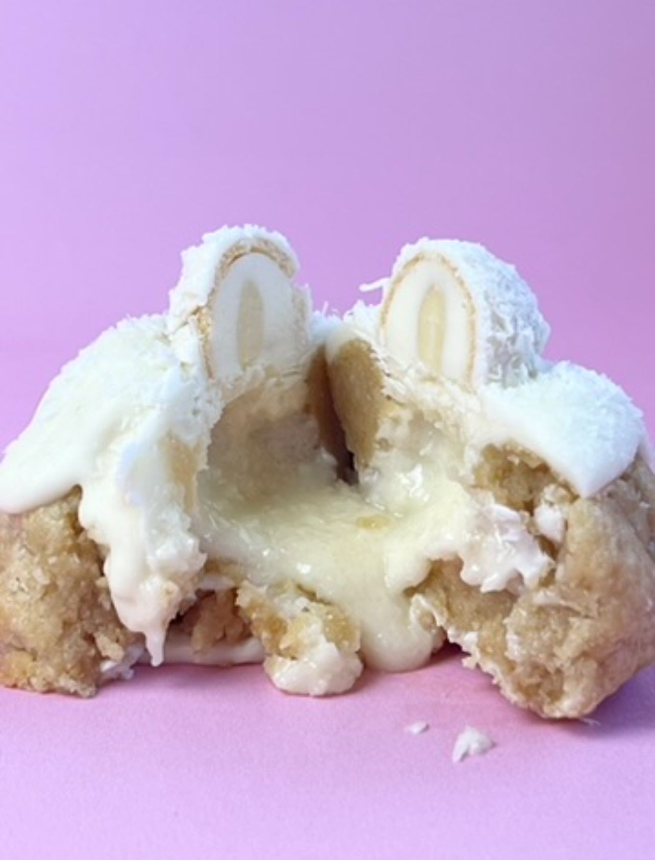 Indulgent shot of the Raffaello Loaded Cookie with gooey white chocolate filling spilling out from the center—pure coconut bliss in every bite.