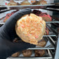 Top view of our Strawberry Shortcake Loaded Cookie, showcasing the white chocolate drizzle, strawberry crumble, and cheesecake frosting peeking through.